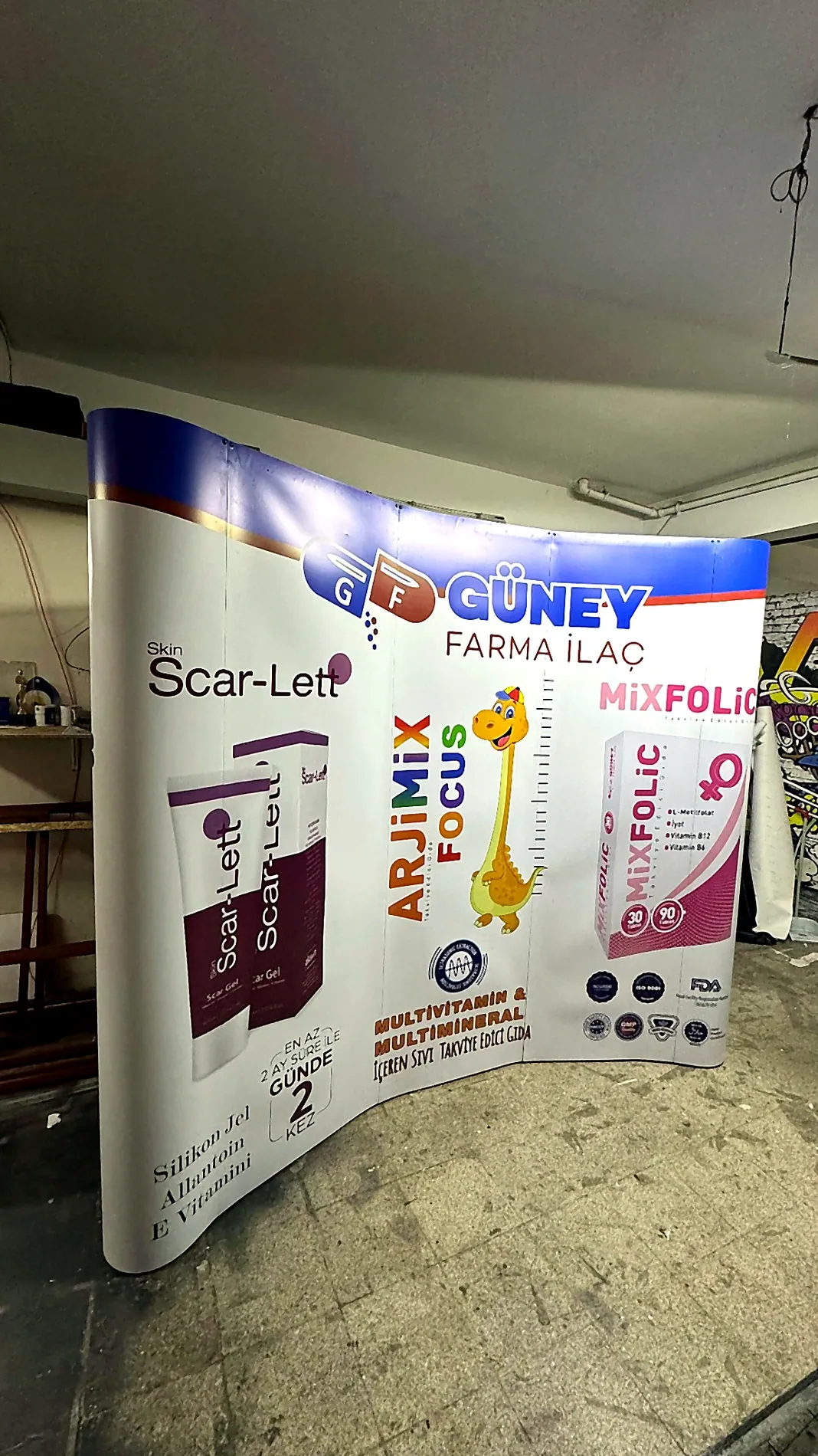 Birden fazla ürünün aynı yüzeyde tanıtıldığı baskılı oval örümcek stand örneği.